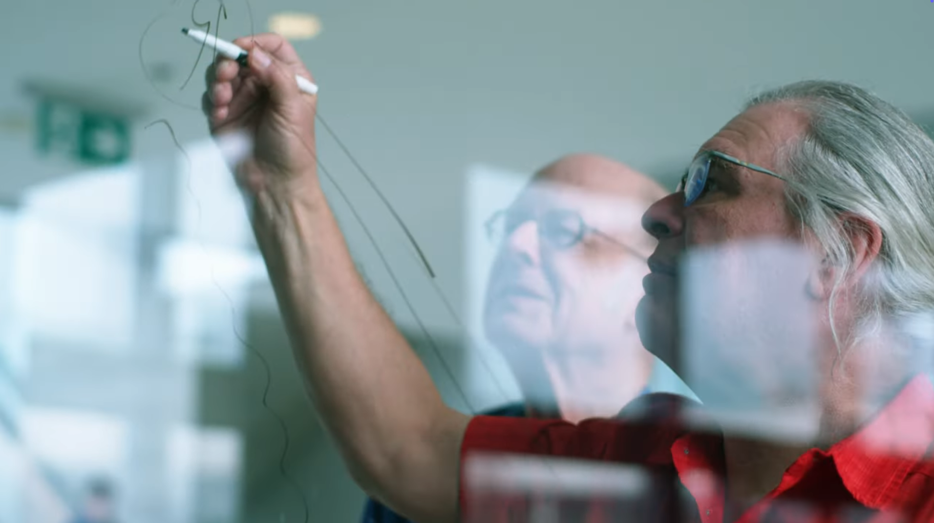 Charles H. Bennett (à gauche) et Gilles Brassard (à droite), lauréats du prix A.M. Turing 2025 de l'ACM, écrivent sur un tableau. 
